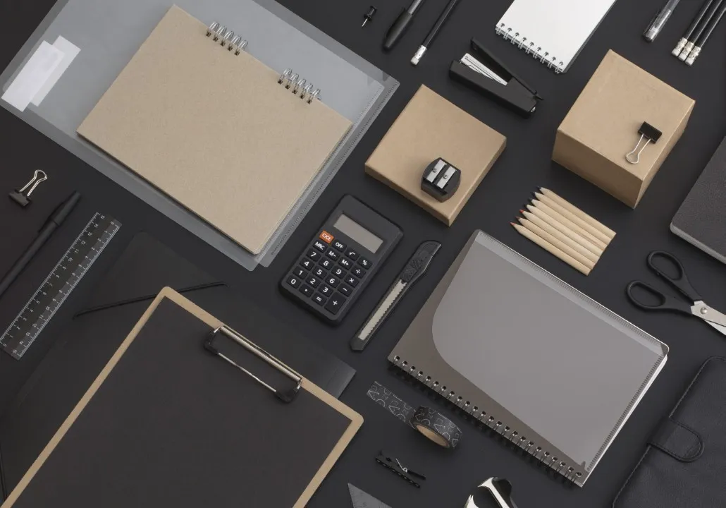 Carpeta negra, hojas grises, tarjetas y lápices negros que forman un set de papelería corporativa.